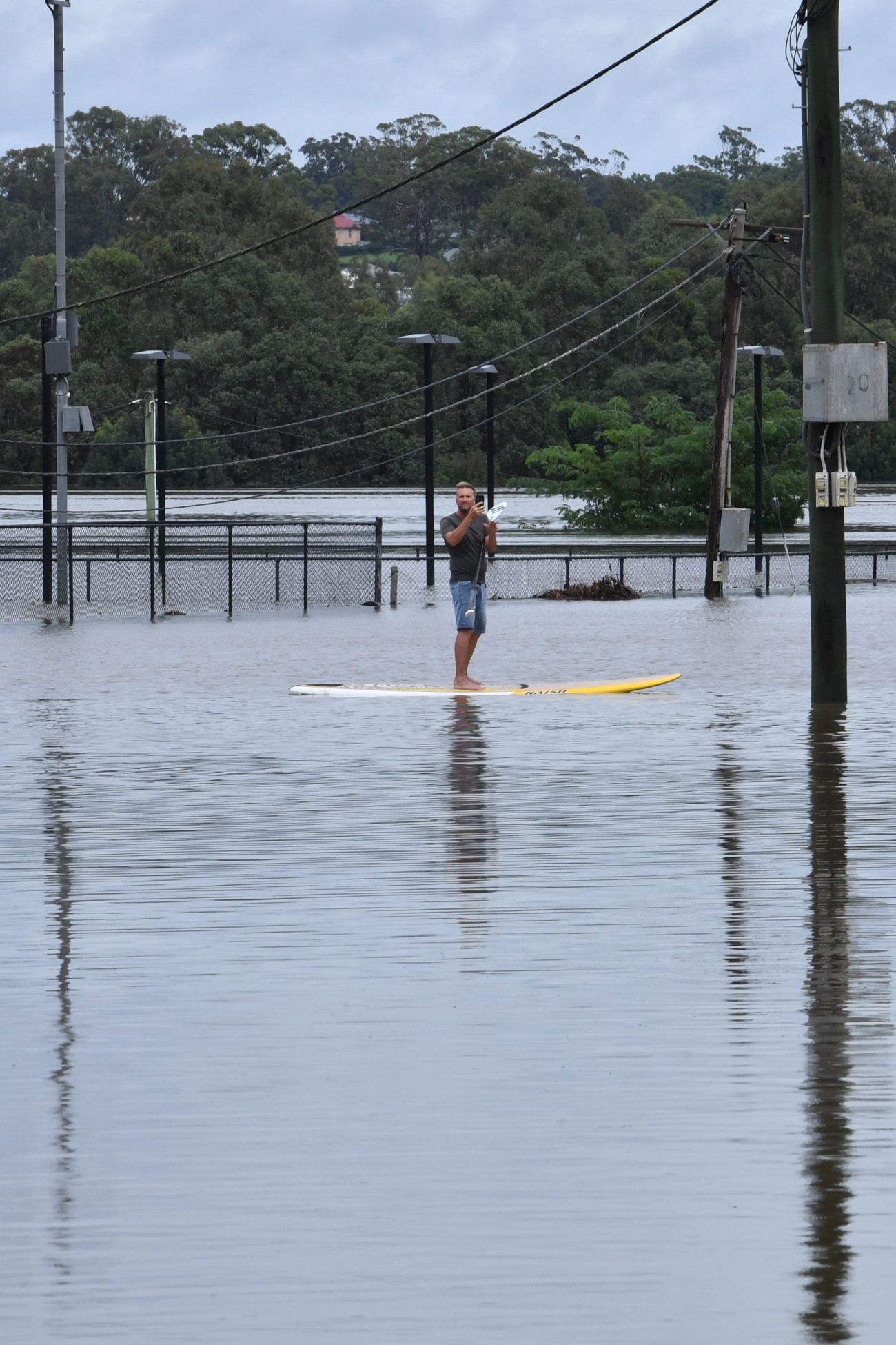 Camden, 2022. március 8.
Szörfdeszkával közlekedő férfi az árvízzel elöntött Camdenben 2022. március 8-án. A heves esőzések miatt áradások sújtják Ausztrália keleti partvidékét. A természeti katasztrófa miatt Új-Dél-Wales államban emberek tízezreit kellett evakuálni.
MTI/EPA/AAP/Dean Lewins
