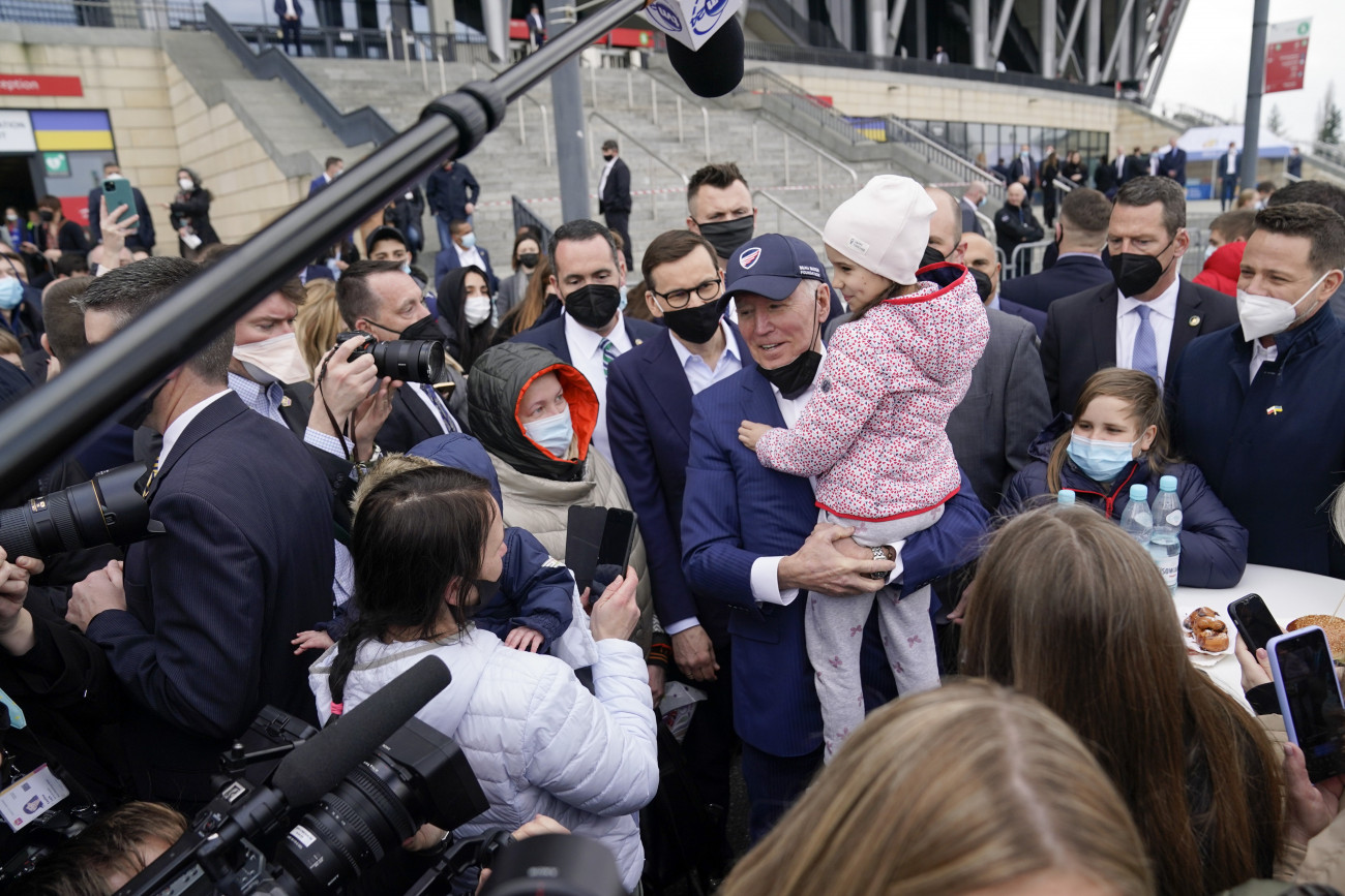 Varsó, 2022. március 26.
Joe Biden amerikai elnök karjában egy kisgyerekkel az ukrajnai menekültek számára létesített központban a varsói Nemzeti Stadionban 2022. március 26-án. Mögötte balról Mateusz Morawiecki lengyel kormányfő. Biden előző nap érkezett kétnapos hivatalos látogatásra Lengyelországba.
MTI/AP/Evan Vucci