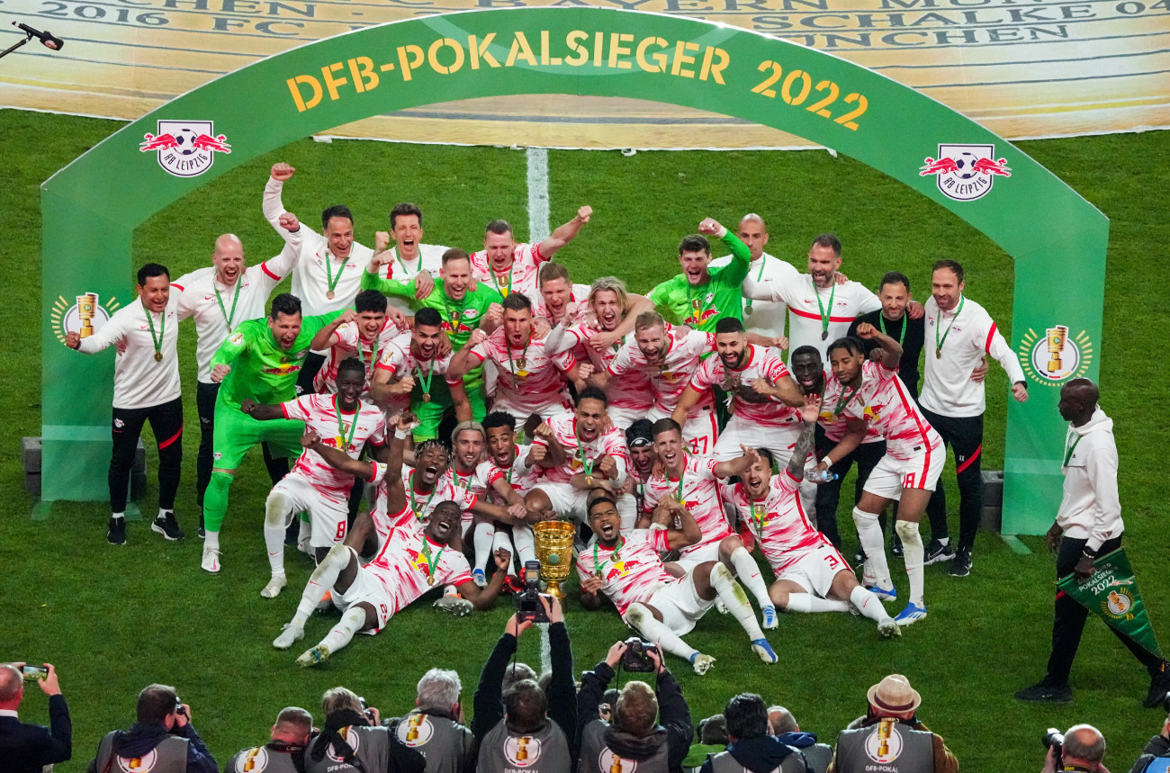 21 May 2022, Berlin: Soccer: DFB Cup, SC Freiburg - RB Leipzig, Final, Olympiastadion. Leipzig's team cheers after winning the match with the DFB Cup in front of the photographers.(IMPORTANT NOTE: In accordance with the requirements of the DFL Deutsche FuĂball Liga and/or the DFB Deutscher FuĂball-Bund, it is forbidden to exploit or have exploited photographs taken in the stadium and/or of the match in the form of sequence pictures and/or video-like photo series). Photo: Soeren Stache/dpa (Photo by Soeren Stache/picture alliance via Getty Images)