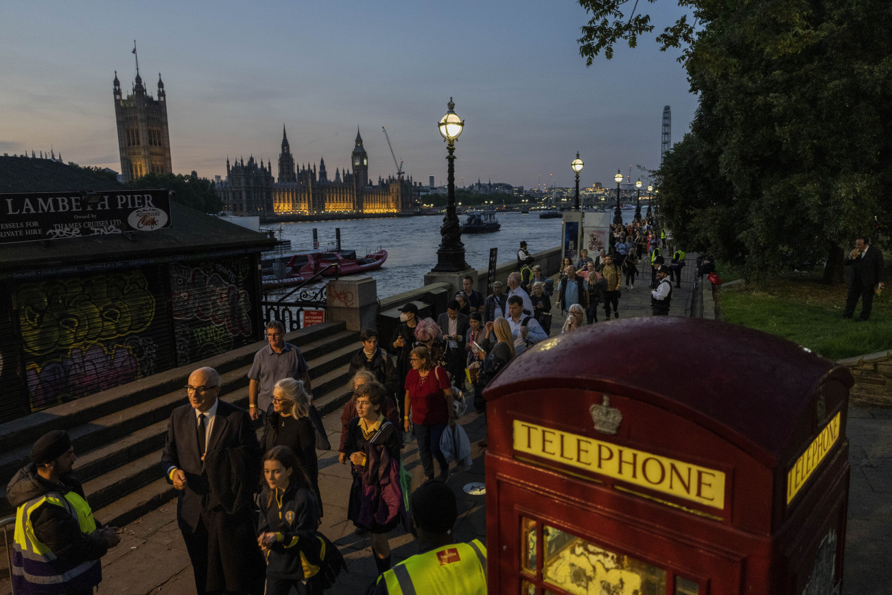 London, 2022. szeptember 14.
Sorban állnak az emberek a Temze partján, hogy leróják kegyeletüket a londoni Westminster-csarnokban felravatalozott II. Erzsébet királynő előtt 2022. szeptember 14-én. A szeptember 8-án, 96 éves korában, uralkodásának 71. évében elhunyt királynőt négy napra, a szeptember 19-i temetésig ravatalozták fel a történelmi csarnokban.
MTI/AP/Bernat Armangue