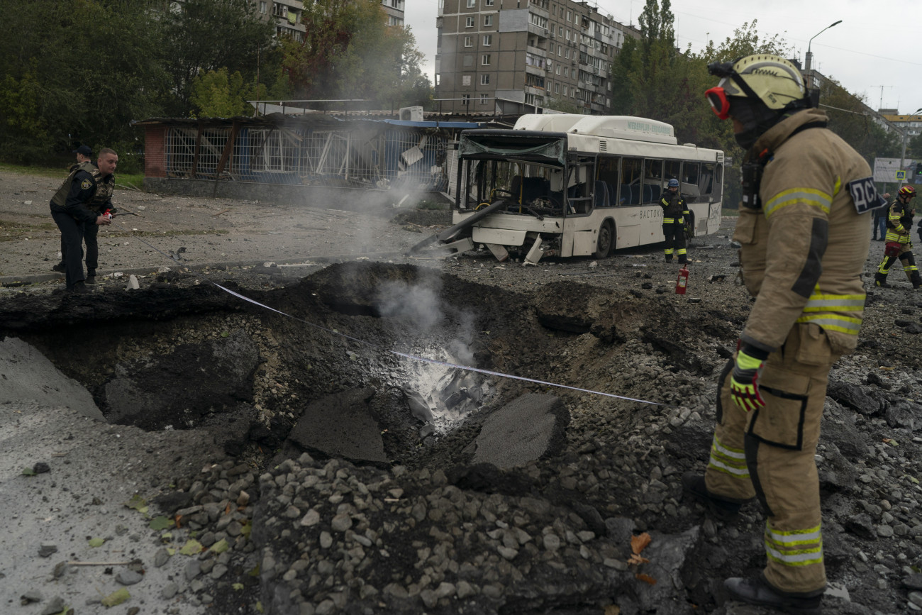 Dnyipro, 2022. október 10.
Bombatölcsér mellett tűzoltók és rendőrök Dnyipróban 2022. október 10-én, miután orosz rakétatámadás érte az ukrajnai várost.
MTI/AP/Leo Correa