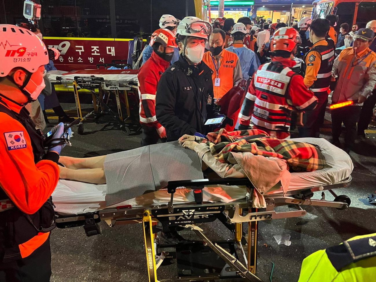 Szöul, 2022. október 29. Hordágyon szállítanak el mentősök egy sérültet Szöulban, ahol legkevesebb százhúsz ember meghalt, százan pedig megsérültek a halloween-ünnepségek idején az egyik szűk utcán kitört lökdösődésben 2022. október 29-én. MTI/EPA/Dzson Hon Kjun