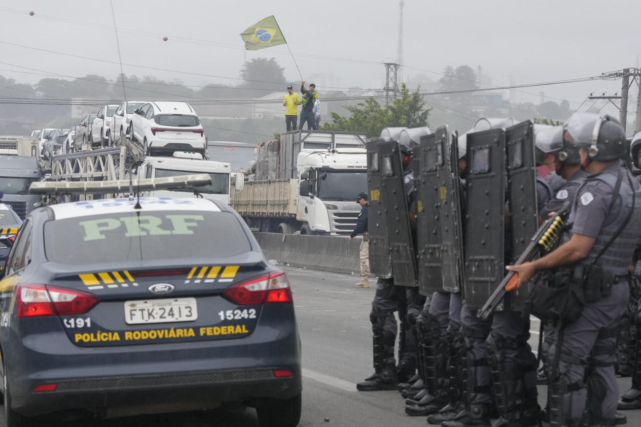 Sao Paulo, 2022. november 1.
Rohamrendőrök sorfalat állnak a Jair Bolsonaro brazil elnököt támogató teherautó-sofőrök előtt, akik járműveikkel akadályozzák a forgalmat egy autópályán Sao Paulóban 2022. november 1-jén, miután a baloldali Luiz Inacio Lula da Silva nyerte meg az előző vasárnap tartott elnökválasztást.
MTI/AP/Andre Penner