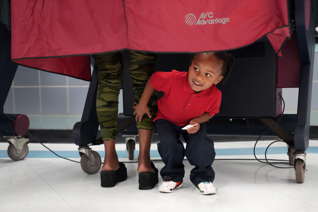 New Orleans, 2022. november 8.
A hároméves Kash Strong kiles egy szavazófülke függönye alól, miközben az édesanyja, Sophia Amacker szavaz az amerikai félidős kongresszusi választásokon a Louisiana állambeli New Orleansban 2022. november 8-án.
MTI/AP/Gerald Herbert