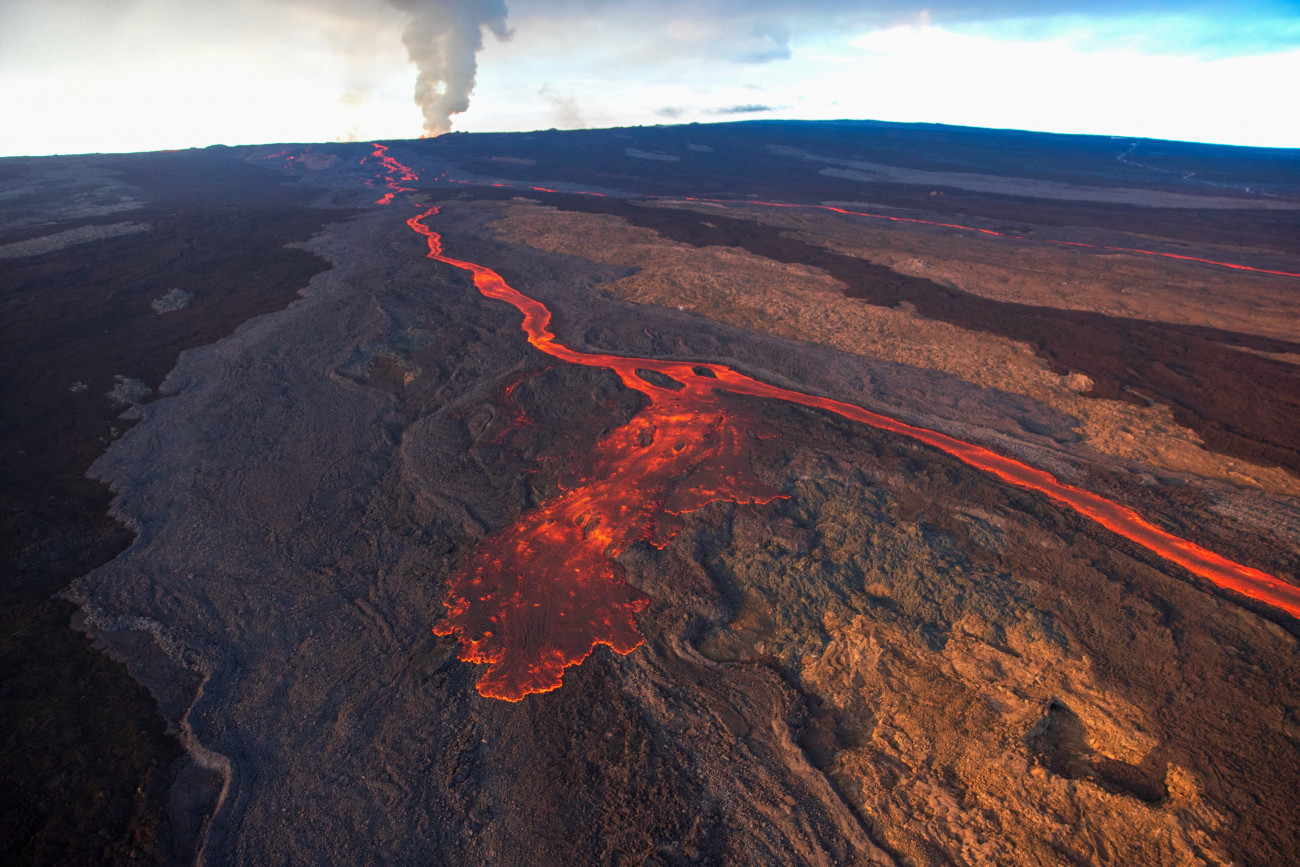Vörösen izzó lávafolyam ömlik le a világ legnagyobb működő vulkánja, a Mauna Loa Mokuaweoweo kráteréből a hawaii Nagy-szigeten lévő Hilo település közelében 2022. november 30-án, két nappal a tűzhányó kitörése után. 
Forrás: MTI/EPA/Bruce Omori.