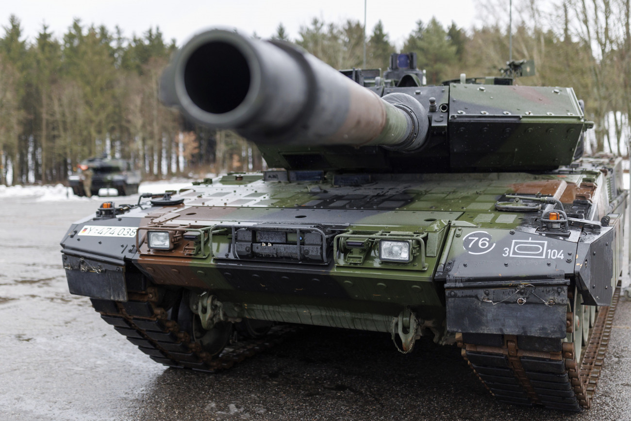 Pfreimd, 2023. február 3.
A német hadsereg 104-es harckocsizászlóaljának egyik új Leopard 2 A7V tankja a szállítmány ünnepélyes átadásán a bajorországi Pfreimd laktanyájában 2023. február 3-án. A Krauss-Maffei-Wegmann német hadiipari vállalat gyártotta Leopard 2 harckocsikat 1979-ben állította hadrendbe az ország hadserege, a Bundeswehr, amelynek azóta is a fő harckocsitípusa. A Leopard 2-es sorozat legutóbbi fejlesztésű A7V alváltozatának tömege mintegy 67 tonna, beszerzési ára darabonként 15-20 millió euró (5,9- 7,9 milliárd forint) között van. Valamennyi korábbi Leopard 2 típus továbbfejleszthető erre a variánsra, a Bundeswehr összesen 150 darab A6-ot fejleszt tovább.
MTI/AP/DPA/Daniel Karmann