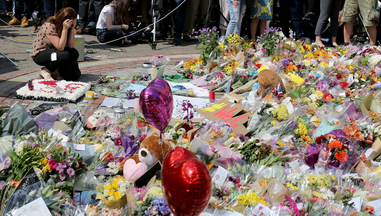 Manchester, 2017. május 25.
Gyászolók egyperces néma csenddel adóznak a manchesteri terrorcselekmény áldozatainak emléke előtt a manchesteri Szent Anna téren 2017. május 25-én. Május 22-én este, Ariana Grande amerikai énekesnő koncertjének végén öngyilkos merénylő pokolgépet robbantott a Manchester Arena nevű rendezvényközpont bejárati csarnokában. A merényletben 22-en életüket vesztették, 59-en megsérültek. (MTI/EPA/Nigel Roddis)