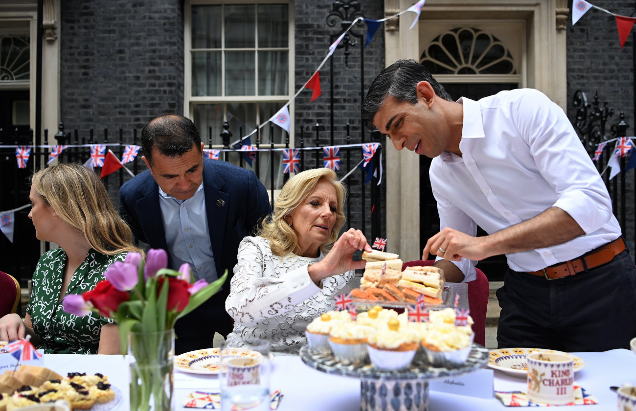 London, 2023. május 7.
Jill Biden, Joe Biden amerikai elnök felesége és Rishi Sunak brit miniszterelnök (j) a londoni kormányfői rezidenciánál tartott utcabálon 2023. május 7-én, III. Károly brit király koronázási ünnepségének másnapján. Nagy-Britanniában a koronázás alkamából országszerte több tízezer helyi utcabált rendeznek milliók részvételével. A Downing Street-i rendezvényre elsősorban ukrajnai menekülteket és nagy-britanniai helyi közösségekért kiemelkedő munkát végző önkéntes aktivistákat hívtak meg.
MTI/EPA pool/Andy Rain
