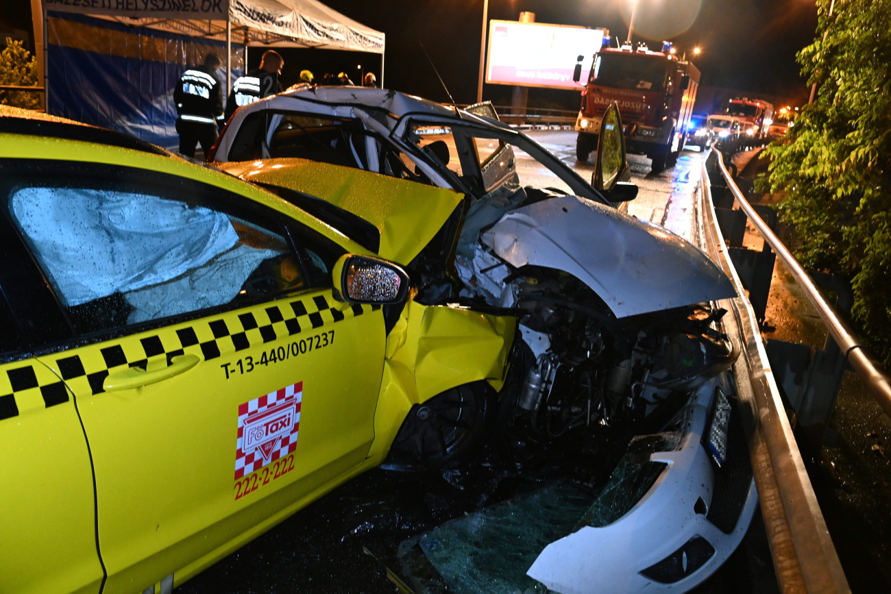 Budapest, 2023. június 6.
Összeroncsolódott személyautó és taxi a ferihegyi repülőtérre vezető úton, a Határ útnál 2023. június 6-ra virradóan. A balesetben egy nő a helyszínen meghalt, többen megsérültek.
MTI/Mihádák Zoltán