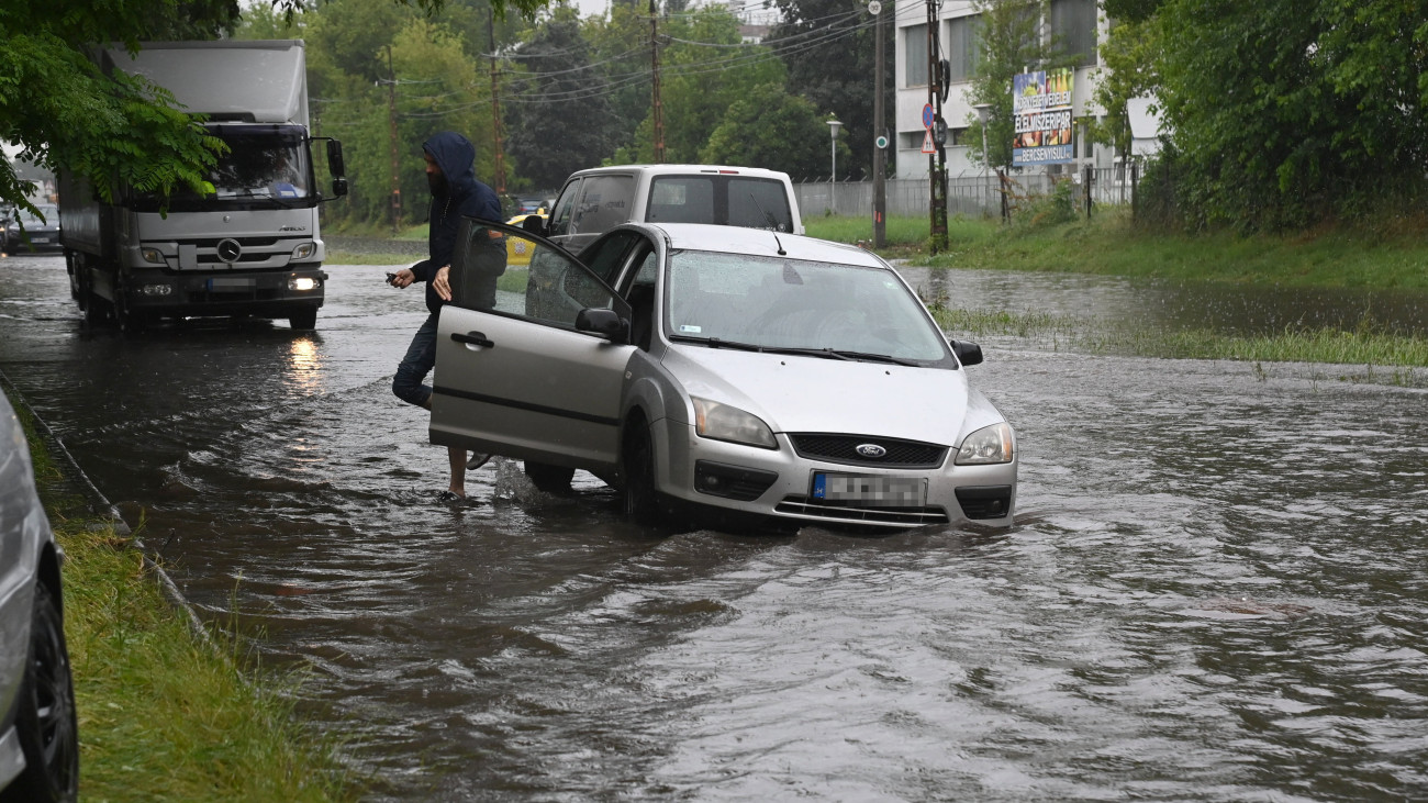Budapest, 2023. június 9.
A felgyülemlett esővíztől elmozdult csatornafedél miatt a vízelvezetőben elakadt személygépkocsi a Maglódi úton 2023. június 9-én.
MTI/Mihádák Zoltán