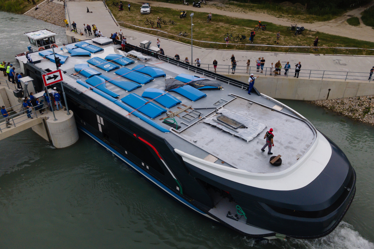 Siófok, 2023. június 28.
A drónnal készült felvételen a Balatoni Hajózási Zrt. (Bahart) egyik új kompját vontatják a Sió-csatorna balatonkiliti duzzasztógátjánál 2023. június 28-án. A Bahart a Magyar Turisztikai Ügynökség (MTÜ) közreműködésével építtetett két új személyhajója és két kompja 2021-ben készült el a komáromi hajógyárban, ahonnan egy héttel ezelőtt indultak útnak, hogy a Dunán lehajózva a Sió-csatornán keresztül elérjék a Balatont.
MTI/Vasvári Tamás