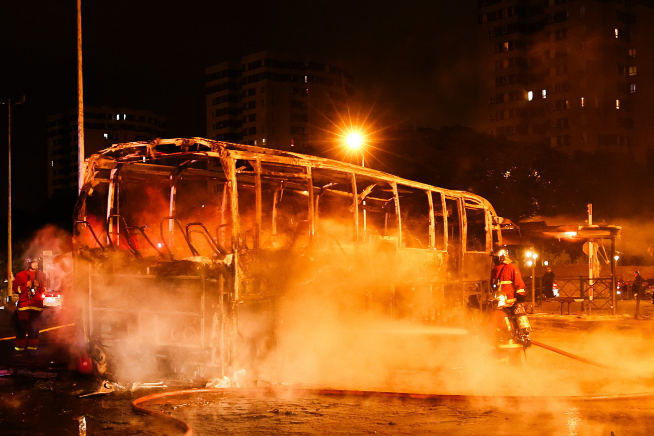 Nanterre, 2023. július 1.
Tüntetők által fegyújtott autóbuszt locsolnak tűzoltók Nanterre-ben 2023. június 30-án este, a városban történt incidens után három nappal. Június 27-én egy közúti ellenőrzést végző rendőr intézkedés közben lelőtt egy 17 éves fiatalt Párizs Nanterre nevű elővárosában. Az eset miatt több francia városban az egymást követő negyedik éjszaka gyújtogattak és fosztogattak a tüntetők. A kormány válságtanácskozást tartott és 45 ezer rendőrt vezényelt Párizs és több francia nagyváros utcáira, hogy megfékezzék a pusztítást. Eddig több mint 1300 rendbontót vettek őrizetbe.
MTI/EPA/Mohamed Badra
