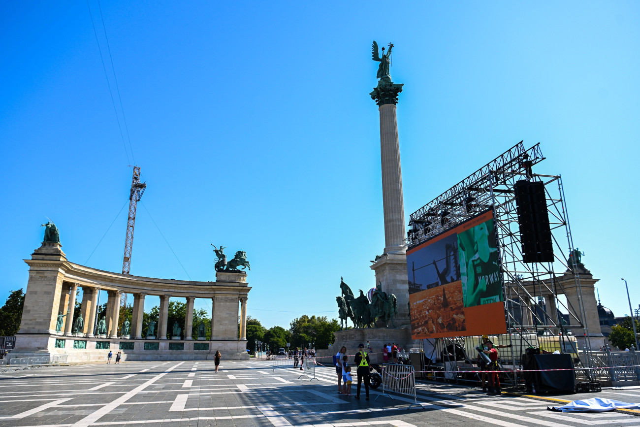 Budapest, 2023. augusztus 14.
A Hősök tere 2023. augusztus 14-én, ahol az öt nap múlva kezdődő atlétikai világbajnokság 49 versenyszámából hatnak, a férfi és női maratonfutásnak, illetve a férfi és női 20 és 35 kilométeres gyaloglásának lesz a rajt- és célterülete, balról a teret a Kodály körönddel összekötő 980 méter hosszú kábelkamera rendszer daruja. A téren már állnak a lelátók, és két óriáskivetítő is működik. Az utcai futóversenyek mentén több szurkolói pontot állítanak majd fel Budapest belvárosában.
MTI/Illyés Tibor