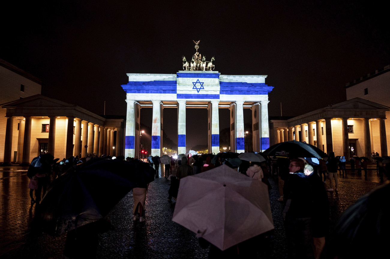 Berlin, 2023. október 8.
Izraeli zászlót vetítenek a Brandenburgi kapura a szolidaritás jeleként Berlinben 2023. október 7-én, miután a Hamász palesztin iszlamista szervezet rakétaáradatot zúdított Izrael déli és középső részére a Gázai övezetből, és több tucat fegyverese hatolt be izraeli településekre. Az izraeli egészségügyi tárca október 8-i közlése szerint 2048 sebesültet szállítottak kórházba, akik közül az életveszélyes és súlyos sebesültek számát háromszázötvenre becsülik.
MTI/AP/DPA/Fabian Sommer