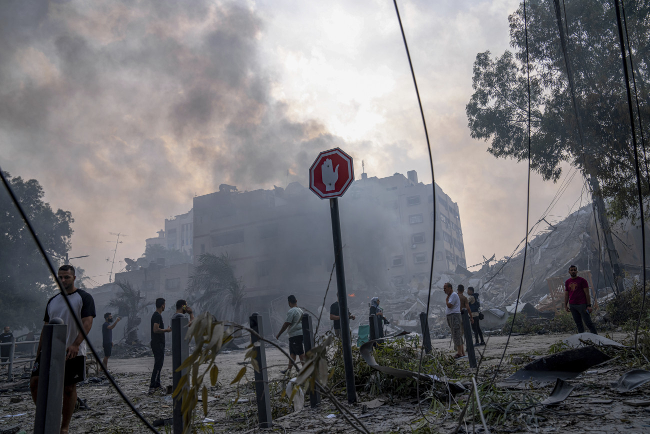 Hán-Júnisz, 2023. október 8.
Izraeli légicsapásokban megrongálódott épületet néznek emberek a Gázai övezetben lévő Hán-Júniszban 2023. október 8-án. Előző nap a Hamász palesztin iszlamista szervezet rakétaáradatot zúdított Izrael déli és középső részére a Gázai övezetből, és több tucat fegyverese hatolt be izraeli településekre. Az izraeli hadsereg ezután ellencsapásokat hajtott végre délen a Gázai övezetet uraló iszlamista Hamász és Iszlám Dzsihád terrorszervezet ellen, valamint északon a libanoni határnál. 
MTI/AP/Fatima Shbair