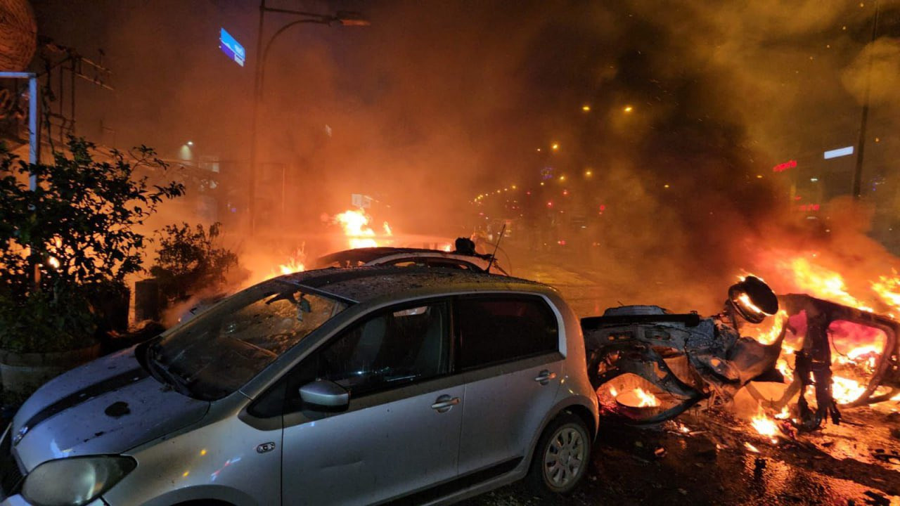 Lángoló roncsok a Hezbollah rakétacsapása után. Forrás: X / OSINTdefender