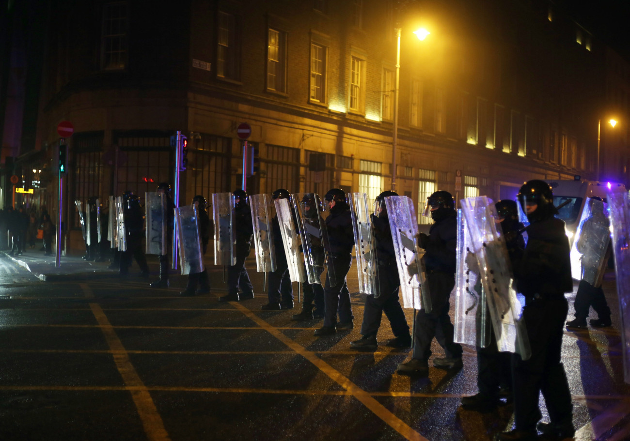 Dublin, 2023. november 24.
Rohamrendőrök sorfallal zárják el az utat tüntetők elől Dublin belvárosában, ahol zavargások törtek ki egy késelés miatt 2023. november 23-án. Órákkal korábban egy férfi öt embert, köztük három gyermeket megsebesített, az egyiküket súlyosan. A rendőrség őrizetbe vette a feltételezett elkövetőt.
MTI/EPA/Mostafa Darwish