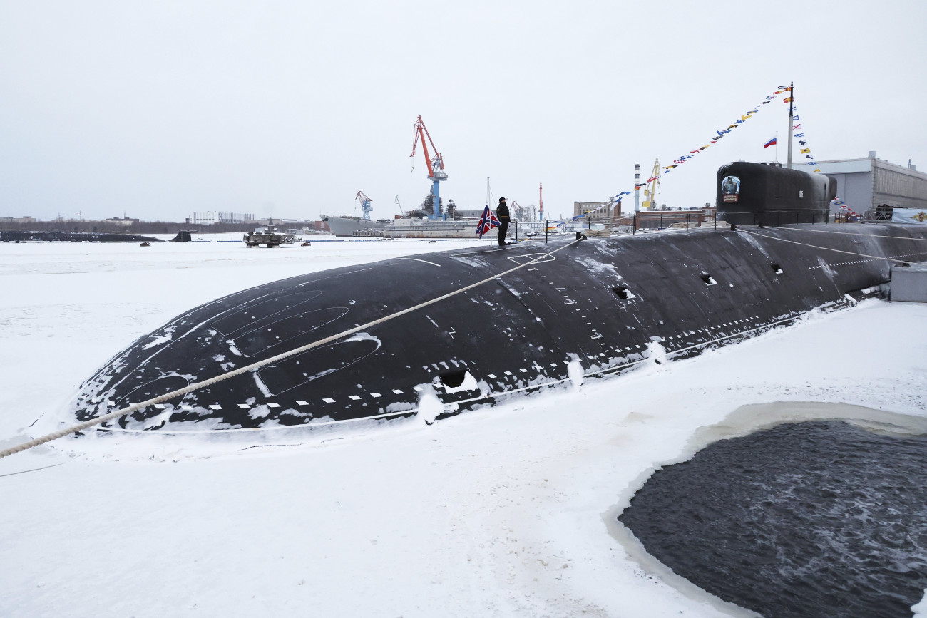 Szeverodvinszk, 2023. december 11.
Az újonnan megépített III. Sándor cár tengeralattjárón áll a legénység tagja az orosz haditengerészet két legújabb nukleáris tengeralattjárójának Vlagyimir Putyin orosz elnök részvételével tartott zászlófelvonási ünnepségén az Északi Gépgyárban (Szevmas), az Arhangelszki régióban levő Szeverodvinszkban 2023. december 11-én. Oroszország hajóraja a III. Sándor cár mellett a Krasznojarszk tengeralattjáróval bővült.
MTI/AP/Szputnyik ppol/Mihail Klimentyev