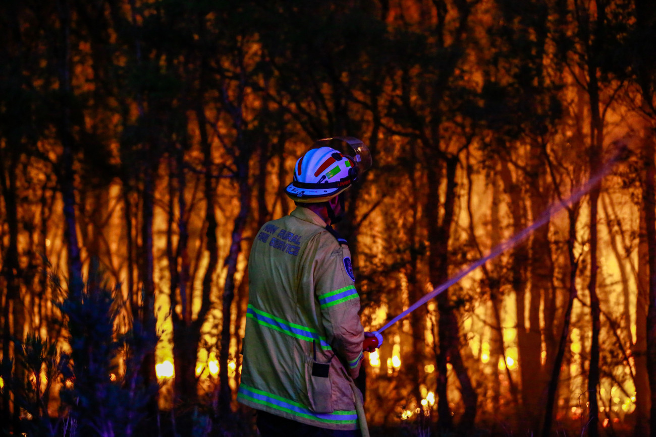 NEWCASTLE, AUSTRALIA - DECEMBER 14: NSW Rural Fire Service firefighter attempt to extinguish a bush fire at West Wallsend on December 14, 2023 in Newcastle, Australia. Several fast-moving bushfires prompted evacuations and warnings in Newcastle and the Hunter Valley, a worrying signal for a potentially devastating wildfire season to come. (Photo by Roni Bintang/Getty Images)