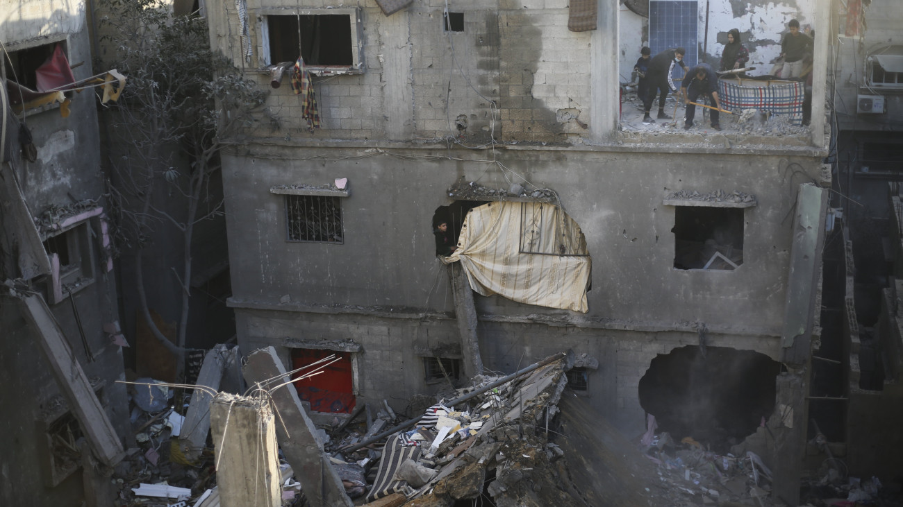 Rafah, 2023. december 24.
Palesztinok takarítanak találatot kapott házuk romjai között egy izraeli légicsapás után a Gázai övezet déli részén fekvő Rafahban 2023. december 24-én. A Hamász palesztin iszlamista szervezet fegyveresei október 7-én támadást indítottak Izrael ellen, az izraeli haderő pedig válaszul légi és szárazföldi hadműveleteket hajt végre a Gázai övezetben.
MTI/AP/Hatem Ali