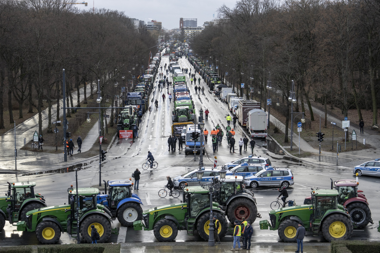 Berlin, 2024. január 15.
Tüntető gazdálkodók traktorokkal és járművekkel a berlini kormányzati negyedben 2024. január 15-én. A parasztgazdák a mezőgazdasági adókedvezmények jelentős csökkentése miatt tiltakoznak.
MTI/AP/Ebrahim Noruzi
