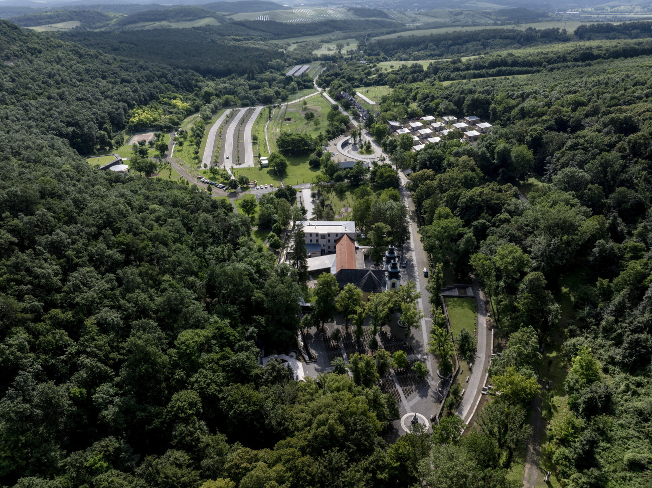 Mátraverebély, 2024. június 12.
A drónnal készült képen a mátraverebély-szentkúti nemzeti kegyhely az új létesítmények átadásának napján, 2024. június 12-én. Családbarát beruházásokat, többek között 16 apartmanházat és multifunkcionális sportpályát adtak át a Nógrád vármegyei Mátraverebély-Szentkúton lévő római katolikus nemzeti kegyhelyen. A négy év alatt elkészült fejlesztésekre 3 milliárd 409 millió forintot biztosított a Magyar Turisztikai Ügynökség.
MTI/Komka Péter