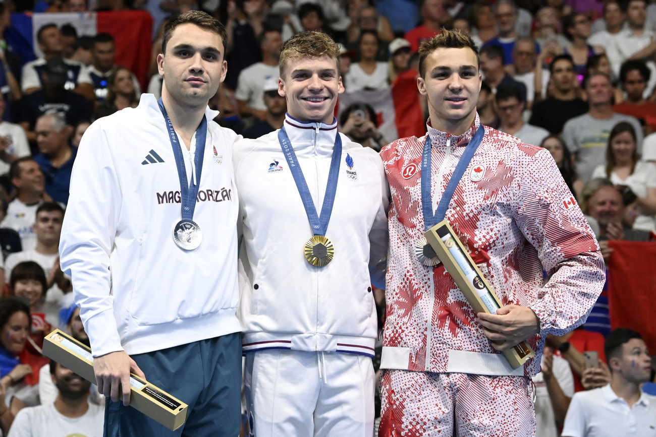 Nanterre, 2024. július 31.
Az aranyérmes francia Léon Marchand (k), az ezüstérmes Milák Kristóf (b) és a bronzérmes kanadai Ilya Kharun (j) a férfi 200 méteres pillangóúszás eredményhirdetésén a 2024-es párizsi nyári olimpián a Párizs melletti Nanterre-ben lévő Paris La Défense Arénában 2024. július 31-én.
MTI/Kovács Tamás