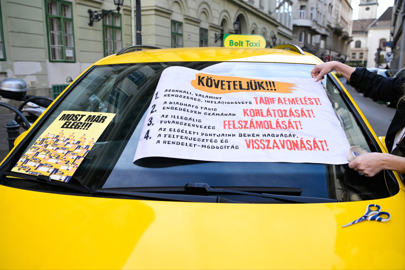 Budapest, 2025. október 29.
Taxi a Fõvárosi Közgyûlés ülése alatt Városháza elõtt 2025. október 29-én. A taxisok tarifaemelést követelnek, valamint egyebek mellett szorgalmazzák az engedélyek számának korlátozását, az illegális fuvarszervezés felszámolását.
MTI/Purger Tamás