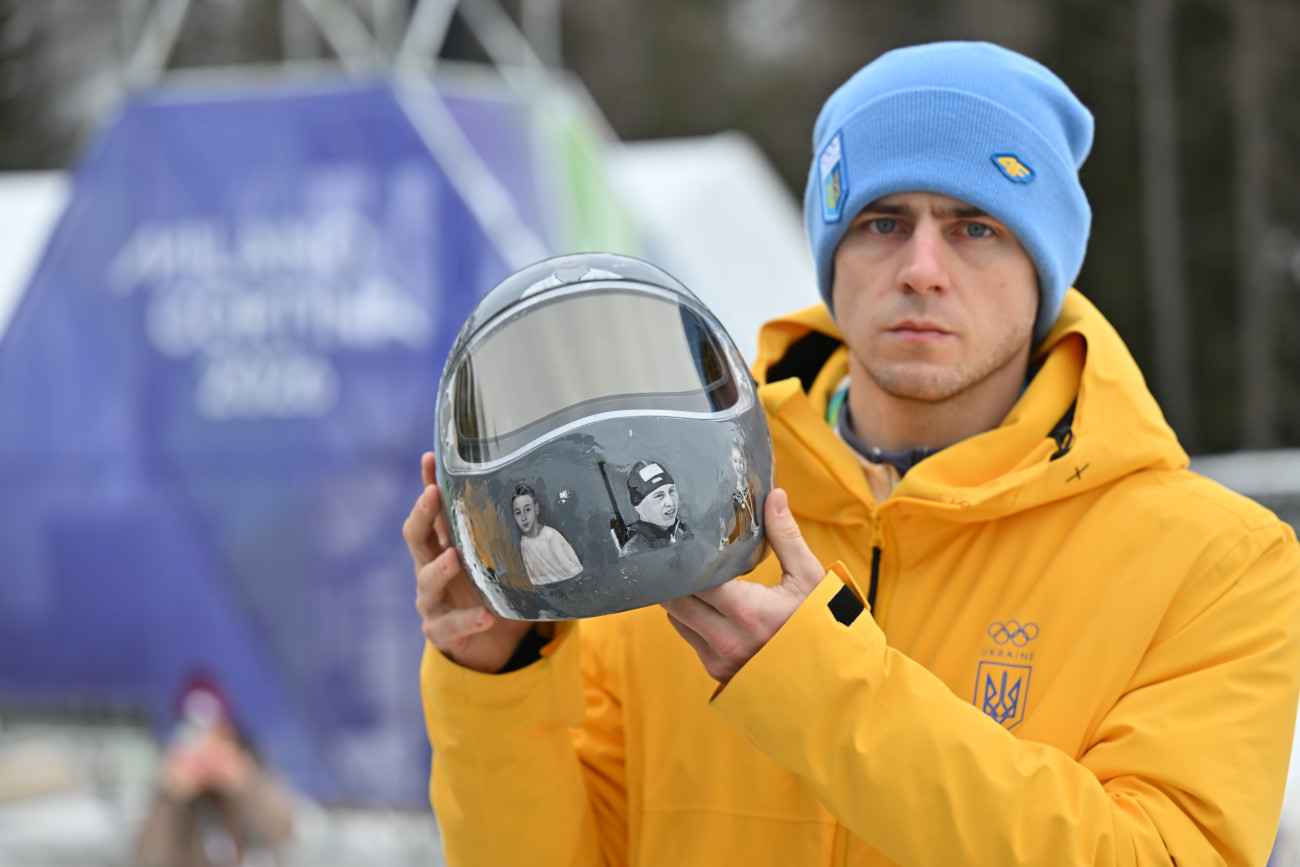 12 February 2026, Italy, Cortina d'Ampezzo: Olympia, Olympic Winter Games Milan Cortina 2026, Skeleton, Men, Vladislav Heraskevych (Ukraine) shows his helmet. The Ukrainian Vladislav Heraskevych has been banned from the Olympic skeleton competition in a dispute over his helmet with pictures of fellow athletes killed in the war. Photo: Robert Michael/dpa (Photo by Robert Michael/picture alliance via Getty Images)