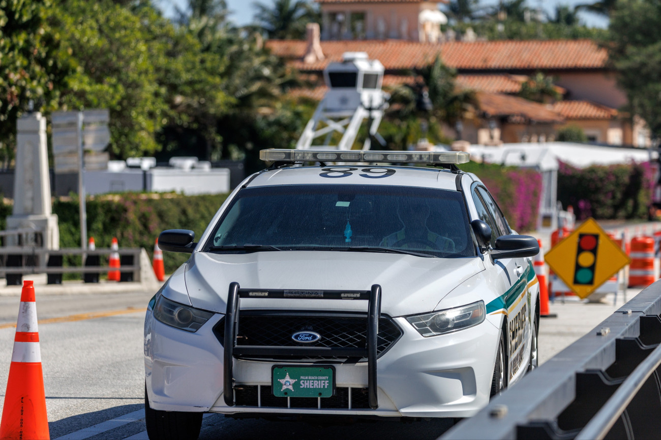 West Palm Beach, 2026. február 22.
A Palm Beach megyei seriffi hivatal járõrautója Donald Trump amerikai elnök mar-a-lagói rezidenciájának közelében, a floridai West Palm Beachben 2026. február 22-én, miután hajnalban egy puskával felfegyverzett férfi benzineskannával megpróbált behatolni az elnök birtokára. A hatóságok agyonõtték a 21 éves férfit, az észak-karolinai illetõségû Austin Tucker Martint. Az incidens idején Trump nem tartózkodott a birtokon.
MTI/EPA/Cristobal Herrera