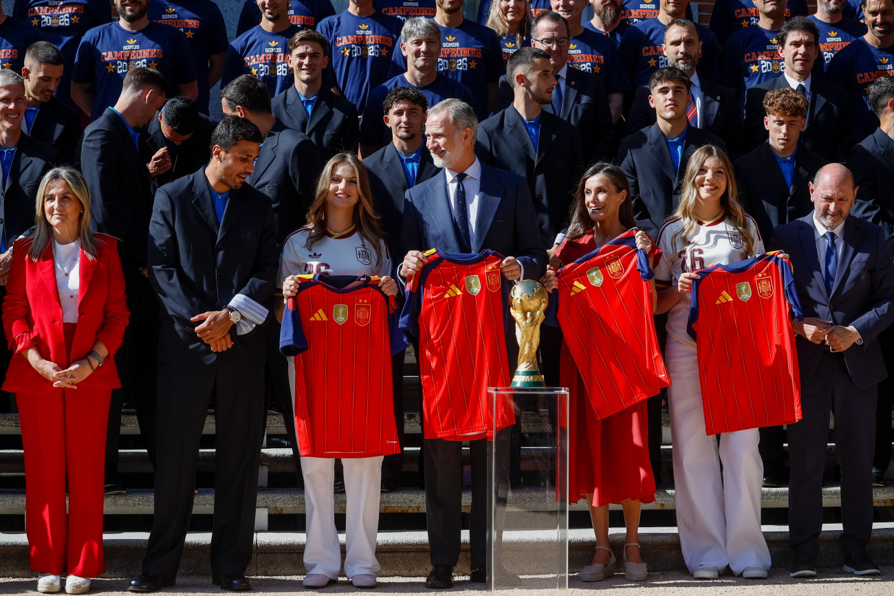 Madrid, 2026. július 20.
Rodri spanyol csapatkapitány (b2), Leonóra, Asztúria hercegnõje, trónörökös (b3), VI. Fülöp spanyol király (k), a felesége, Letizia királyné (j3), Zsófia infánsnõ (j2) és Rafael Louzan, a Spanyol Királyi Labdarúgó-szövetség elnöke (j), amint a világbajnok spanyol labdarúgó-válogatott bemutatja a trófeát a spanyol királyi családnak a madridi Zarzuela-palotánál 2026. július 20-án. Spanyolország az elõzõ nap hosszabbításban 1-0-ra gyõzött Argentína ellen a 2026-os labdarúgó-világbajnokság döntõjében.
MTI/EPA/EFE/Daniel González