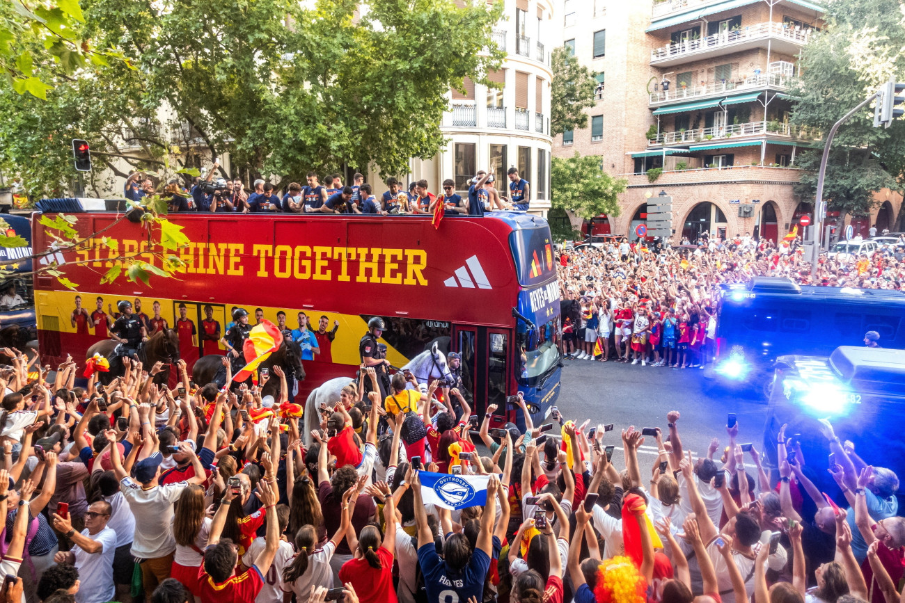 Madrid, 2026. július 20.
A világbajnok spanyol labdarúgó-válogatott nyitott tetejû autóbuszon diadalmenetben hajtat végig Madrid utcáin 2026. július 20-án. Spanyolország az elõzõ nap hosszabbításban 1-0-ra gyõzött Argentína ellen a 2026-os labdarúgó-világbajnokság döntõjében. A felirat jelentése: a csillagok együtt ragyognak.
MTI/AP/Europa Press/César Vallejo