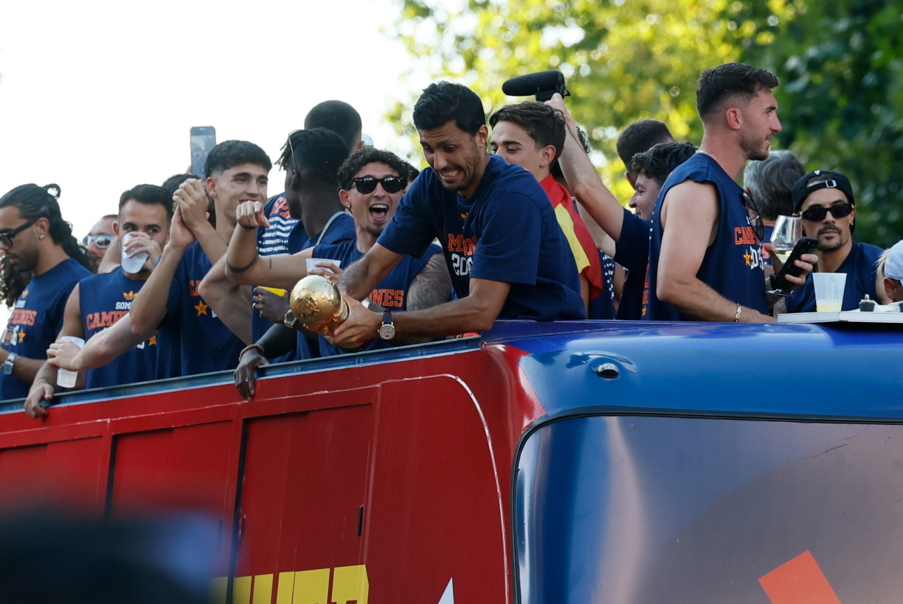 Madrid, 2026. július 20.
A csapatkapitány Rodri fogja a trófeát, amint a világbajnok spanyol labdarúgó-válogatott nyitott tetejû autóbuszon diadalmenetben hajtat végig Madrid utcáin 2026. július 20-án. Spanyolország az elõzõ nap hosszabbításban 1-0-ra gyõzött Argentína ellen a 2026-os labdarúgó-világbajnokság döntõjében.
MTI/EPA/EFE/Ballesteros