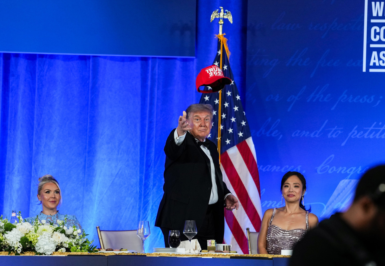 WASHINGTON, DC - JULY 24: U.S. President Donald Trump tosses his TRUMP 2028 hat to an attendee during the re-scheduled White House Correspondents Dinner in the Presidential Ballroom at the Waldorf Astoria on July 24, 2026 in Washington, DC. The annual gala hosted by the White House Correspondents Association was re-scheduled to tonight after the original event in April was cut short when an armed man, later identified as Cole Tomas Allen, attempted to get past a Secret Service checkpoint. (Photo by Eric Lee/Getty Images)