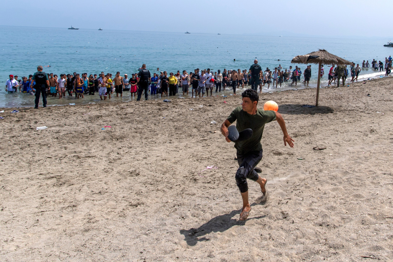 Ceuta, 2026. július 31.
A Spanyolországhoz tartozó Ceutába bejutni próbáló migránsok elõtt a tengerpartot lezáró rendõrök elõl fut egy migráns 2026. július 31-én. Az elõzõ napokban spanyol médiajelentések szerint mintegy ötvenezer ember érkezett illegálisan Marokkóból az észak-afrikai ország területébe ékelõdõ spanyol exklávéba.
MTI/AP/Antonio Sempere