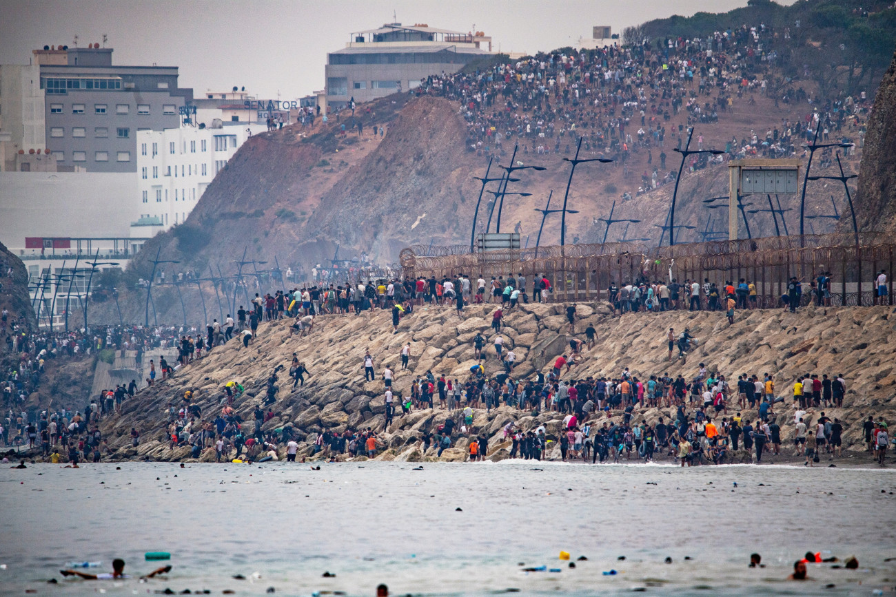 Ceuta, 2026. július 31.
Migránsok a Spanyolországhoz tartozó Ceutából visszatérnek Marokkóba 2026. július 31-én. Az elõzõ napokban spanyol médiajelentések szerint mintegy ötvenezer ember érkezett illegálisan Marokkóból az észak-afrikai ország területébe ékelõdõ spanyol exklávéba, majd a spanyol belügyminisztérium szerint mintegy huszonötezer határsértõ visszaatért Marokkóba.
MTI/AP/Antonio Sempere