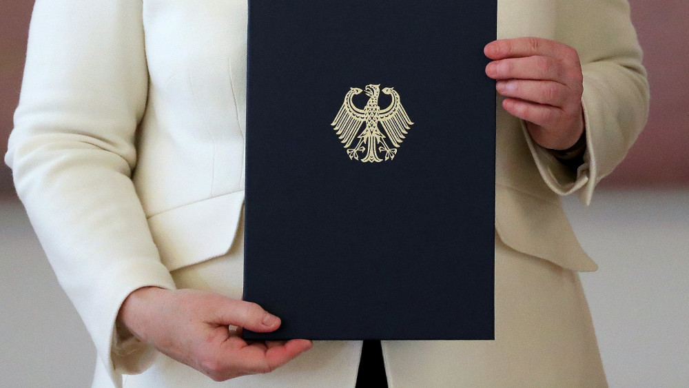 Berlin, 2018. március 14.Angela Merkel újraválasztott német kancellár kinevezési okmányával, amelyet Frank-Walter Steinmeier német elnöktől vett át a berlini államfői rezidencián, a Bellevue-palotában a megválasztása után, 2018. március 14-én. (MTI/EPA/Armando Babani)