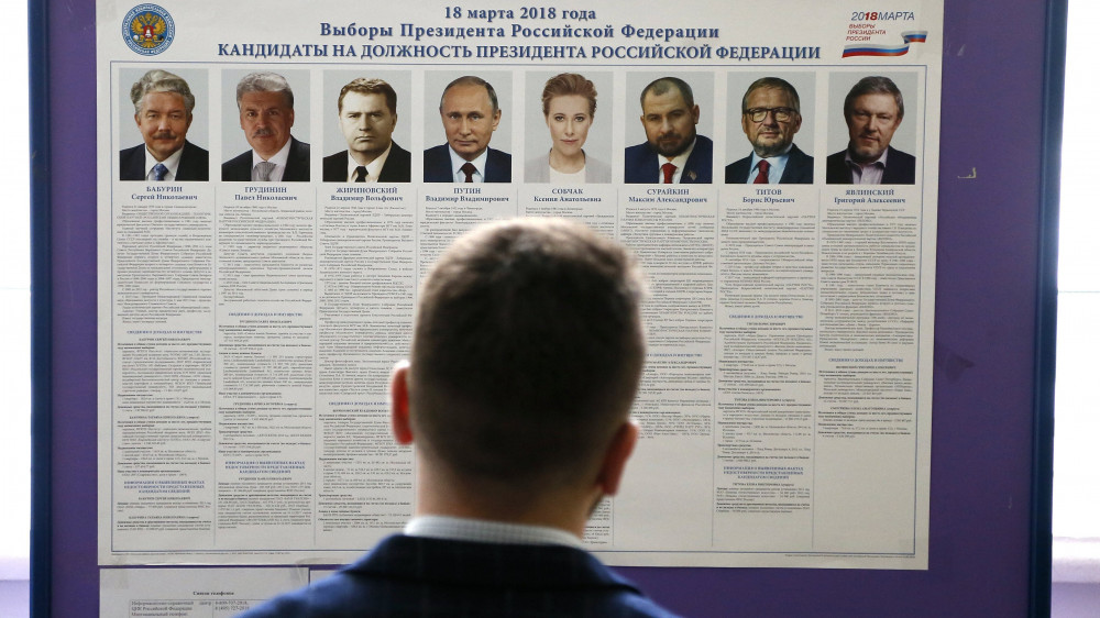 Borovszk, 2018. március 17.Az elnökválasztáson újra induló Vlagyimir Putyin hivatalban levő orosz államfő (b4) és vetélytársai politikai programját olvassa egy férfi egy moszkvai iskolában kialakított szavazóhelyiségben 2018. március 17-én, az orosz elnökválasztás előtti napon. (MTI/EPA/Makszim Sipenkov)