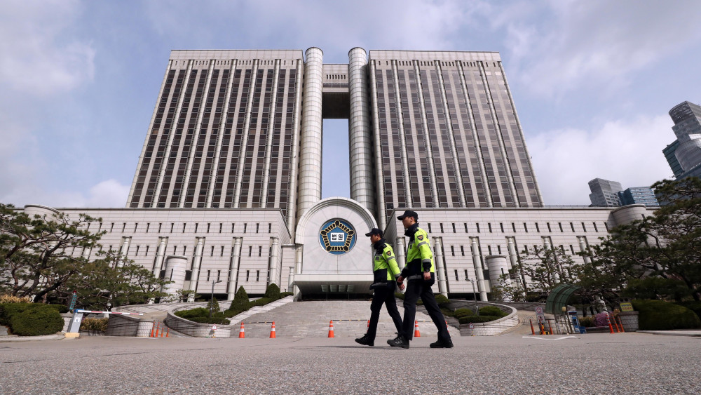 Szöul, 2018. április 6.Rendőrök járőröznek a szöuli kerületi bíróság épülete előtt, ahol tüntetők követelik Pak Gun Hje leváltott dél-koreai elnök szabadon bocsátását 2018. április 6-án. A zsarolással, hivatali visszaéléssel és vesztegetéssel vádolt Pak perében ezen a napon hirdetnek  ítéletet. (MTI/EPA/Yonhap)