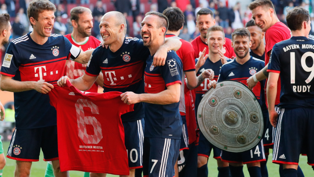 Augsburg, 2018. április 7.A Bayern München játékosai ünnepelnek a bajnoki trófeát jelképező kartonlappal a német első osztályú labdarúgó-bajnokság 29. fordulójában az FC Augsburg ellen játszott mérkőzés végén Augsburgban 2018. április 7-én, miután a bajor csapat a 4-1 arányú győzelmével sorozatban a hatodik bajnoki címét nyerte el. (MTI/EPA/Ronald Wittek)