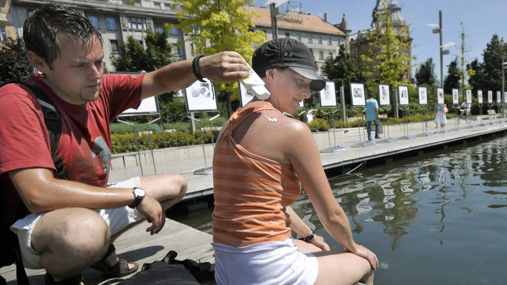 Cseh turista keni be barátnőjét napvédővel a hőségben az Erzsébet téren. Június 23-án az erős ultraibolya-sugárzás miatt UV-riasztást adtak ki Magyarországon.