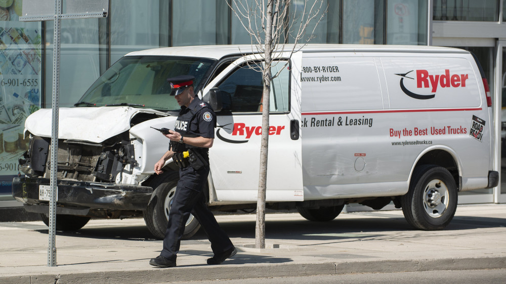 Toronto, 2018. április 24.Sérült furgon előtt egy rendőr Torontóban 2018. április 23-án, miután a jármű gyalogosok közé hajtott a kanadai nagyvárosban. Legalább két ember életét vesztette, a sofőrt elfogták. (MTI/EPA/Warren Toda)