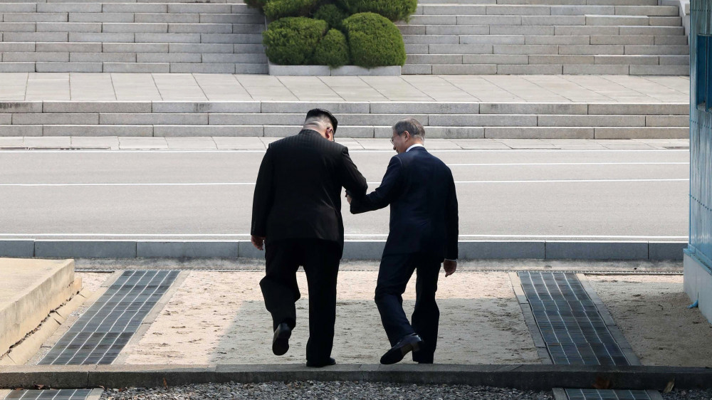 Panmindzson, 2018. április 28.Kim Dzsong Un észak-koreai vezető (b) Mun Dzse In dél-koreai elnökkel lépi át a két Koreát elválasztó demarkációs vonalat a panmindzsoni demilitarizált övezetben, mielőtt tárgyalást kezdenek a déli oldalon levő Béke Házában 2018. április 27-én. Kim Dzsong Un személyében 65 éve először lép észak-koreai vezető dél-koreai területre. (MTI/EPApool/Korea-közi csúcs sajtószolgálata)