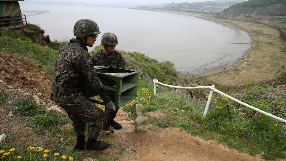 Padzsu, 2018. május 1.Dél-koreai katonák leszerelik a propaganda terjesztésére használt hangszórókat a két Koreát elválasztó panmindzsoni demilitarizált övezetben lévő Padzsuban 2018. május 1-jén. (MTI/EPA pool/Csung Szung Dzsun)
