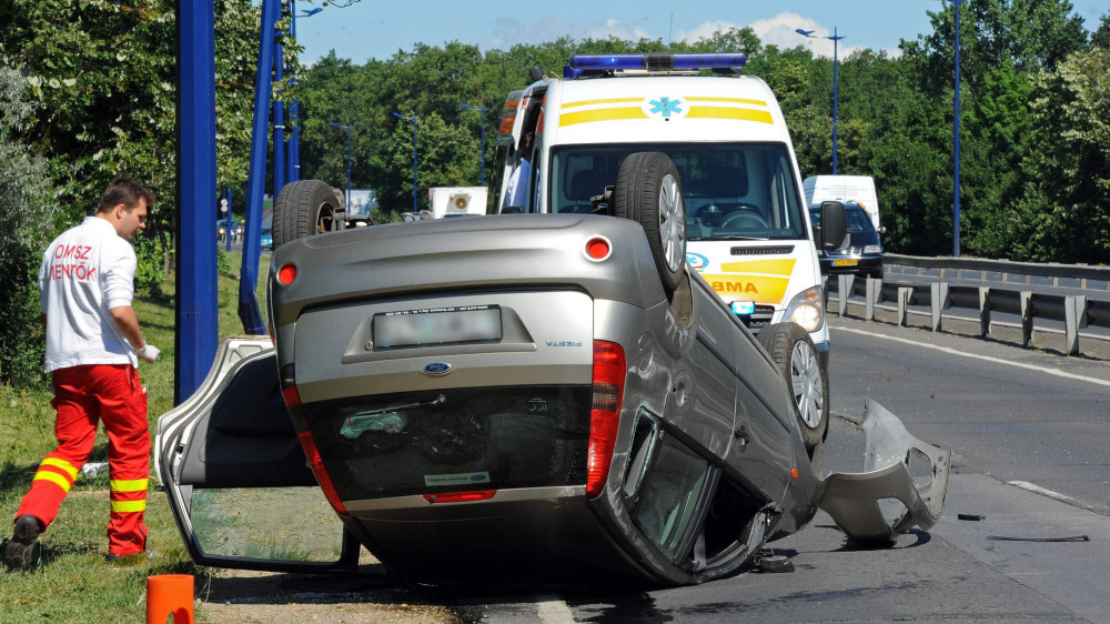 Mentők dolgoznak egy tetejére borult személyautó mellett a X. kerületi Gyömrői úton. A repülőtér irányába tartó jármű a Csévéző utcai kereszteződés után eddig tisztázatlan okból nagy sebességgel egy közvilágítási oszlopnak hajtott, majd az árokba csapódott és az úttestre borult. A balesetben a személyautó vezetője meg sérült, őt a mentők kórházba szállították.