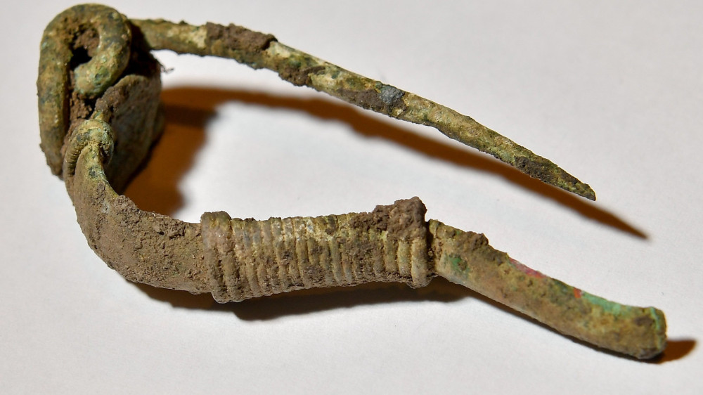 Ezüstből készült fibula (ruhakapocs) a debreceni Déri Múzeumban 2018. május 2-án. A múzeum régészei április 26-án régészeti és történeti szempontból kiemelkedő jelentőségű leletegyüttesre bukkantak Derecske határában, egy gázvezeték nyomvonalán végzett régészeti feltárás közben. A sírban egy férfi, egy nő, egy 10-14 év körüli és egy 1,5-2 éves gyerek csontvázára bukkantak, akiket a római császárkori szarmatáknál jellemző módon, háton fekvő, nyújtott pózban, dél-északi tájolással helyeztek el.