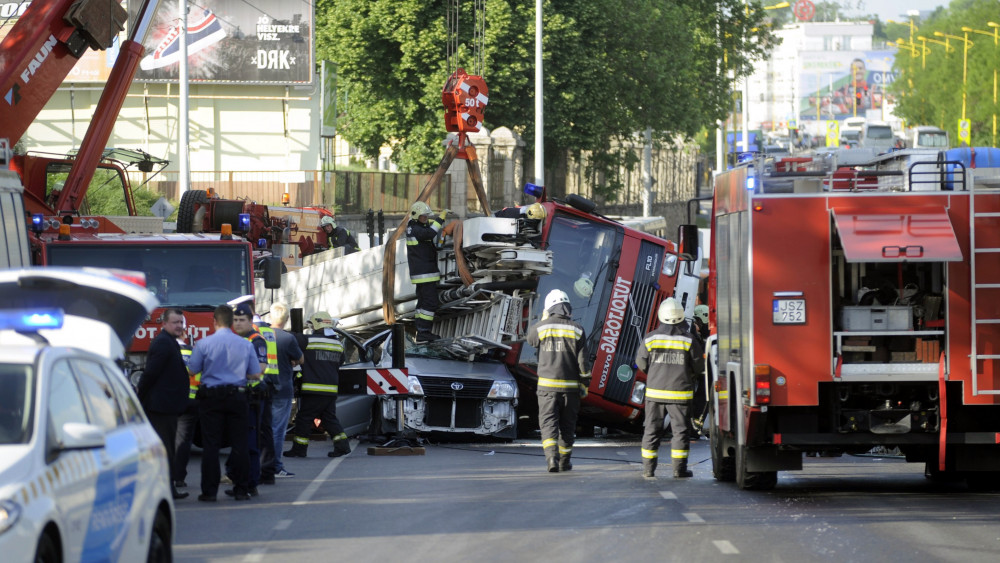 Kisbuszra borult tűzoltóautó emelnek daruval a Nagyszőlős utca és a Budaörsi út kereszteződésében 2018. május 3-án. A tűzoltók egy tűzesethez vonultak kék lámpával, szirénázva, amikor oldalára borult a több tíztonnás gépjármű. A kisbuszban egy ember ült, ő a helyszínen meghalt.