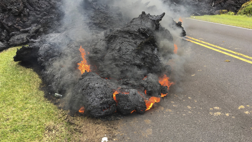 Pahoa, 2018. május 6.A Kilauea tűzhányó lávája ömlik egy úton, a hawaii Pahoa Leilani lakónegyedében 2018. május 5-én. A vulkánkitörés folytatódása miatt újabb kétezer embert költöztettek ki otthonából a hawaii Nagy-szigeten. (MTI/AP/Marco Garcia)
