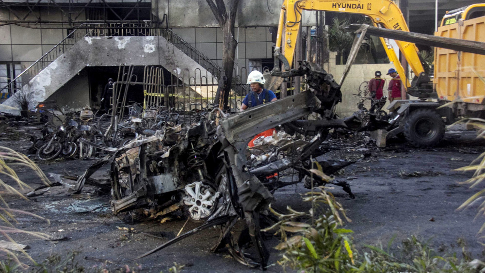 Surabaya, 2018. május 13.Munkagéppel szállítják el a járműroncsokat a kelet-jávai Surabaya város egyik templomától, ahol öngyilkos merénylők robbantottak a reggeli mise előtt 2018. május 13-án. A nagyvárosban három különböző keresztény templomot ért egyidejű pokolgépes támadás, amelyek elkövetője valószínűleg az Iszlám Állam dzsihadista terrorszervezethez kötődő Jamaah Ansharut Daulah nevű indonéziai szélsőséges csoport. (MTI/EPA/Fully Handoko)