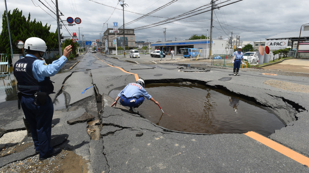 Oszaka, 2018. június 18.Óriási, vízzel teli kráter keletkezett egy megrongált úttesten Oszakában 2018. június 18-án, miután 6,1-es fokozatú földrengés rázta meg Japán nyugati térségét. A természeti csapásban három ember életét vesztette, és több mint kétszázan megsérültek. A rengés központja az oszakai prefektúra északi részén, mintegy 13 kilométeres mélységben volt. (MTI/EPA/Jiji Press)